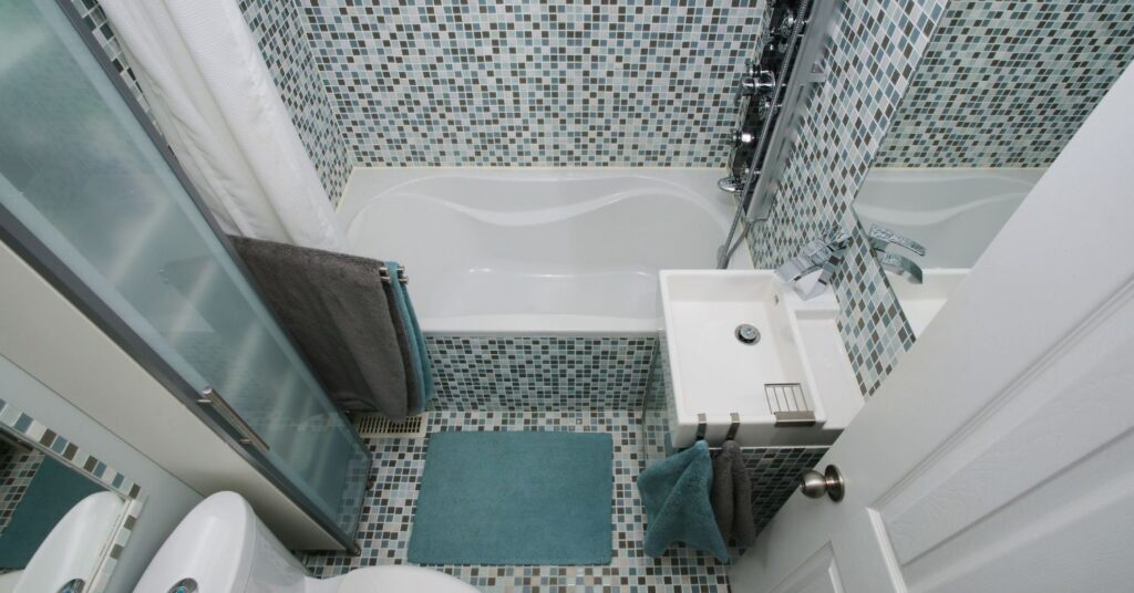 half bathroom with a toilet, sink, and a small tub with shower