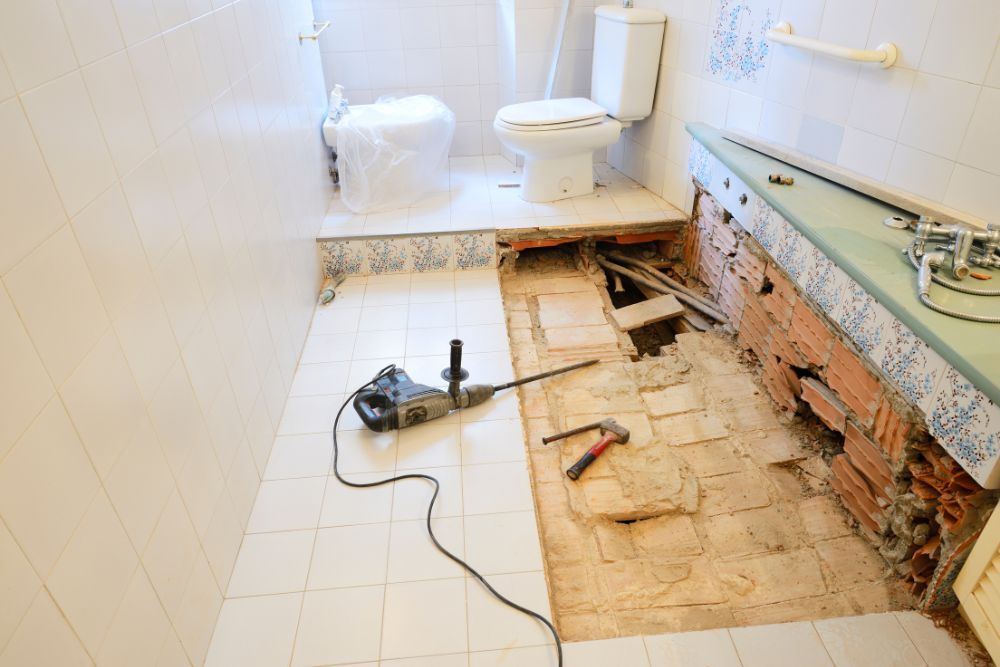 how to remodel a bathroom floor - heavy equipment on a partially demolished floor
