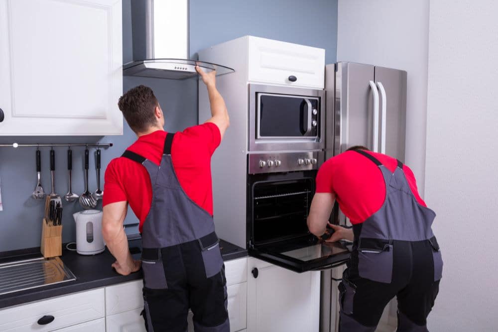 professional remodelers installing kitchen appliances and fixtures