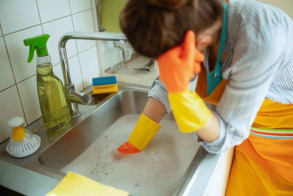 woman working on a clogged sink