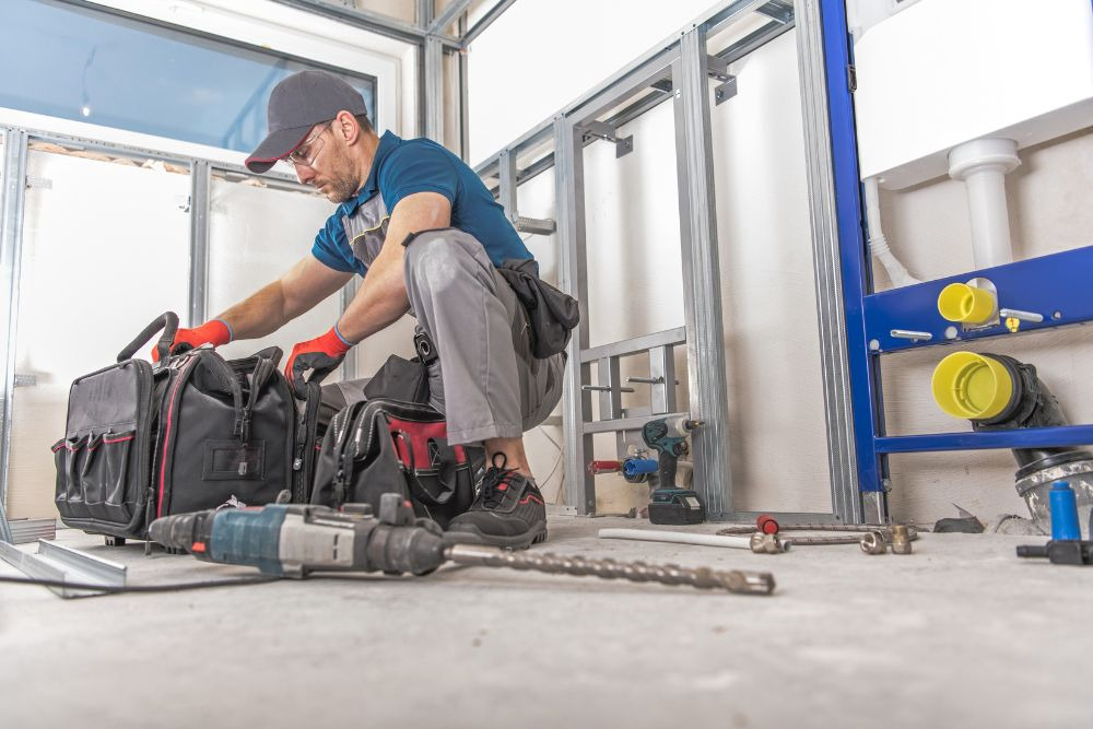 man with duffel bags and power tools getting ready to work on a one day bathroom remodel