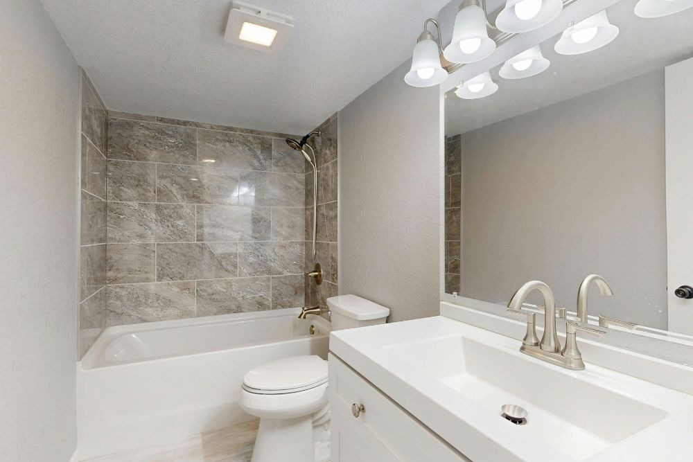 vanity illuminated by overhead led lights and a led ambient light