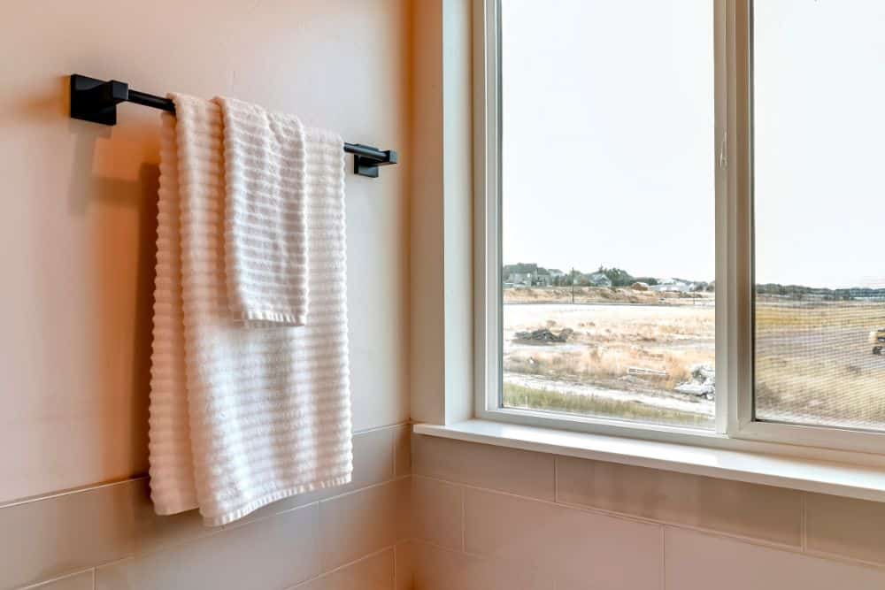 large windows with countryside views by the towel rack in the shower