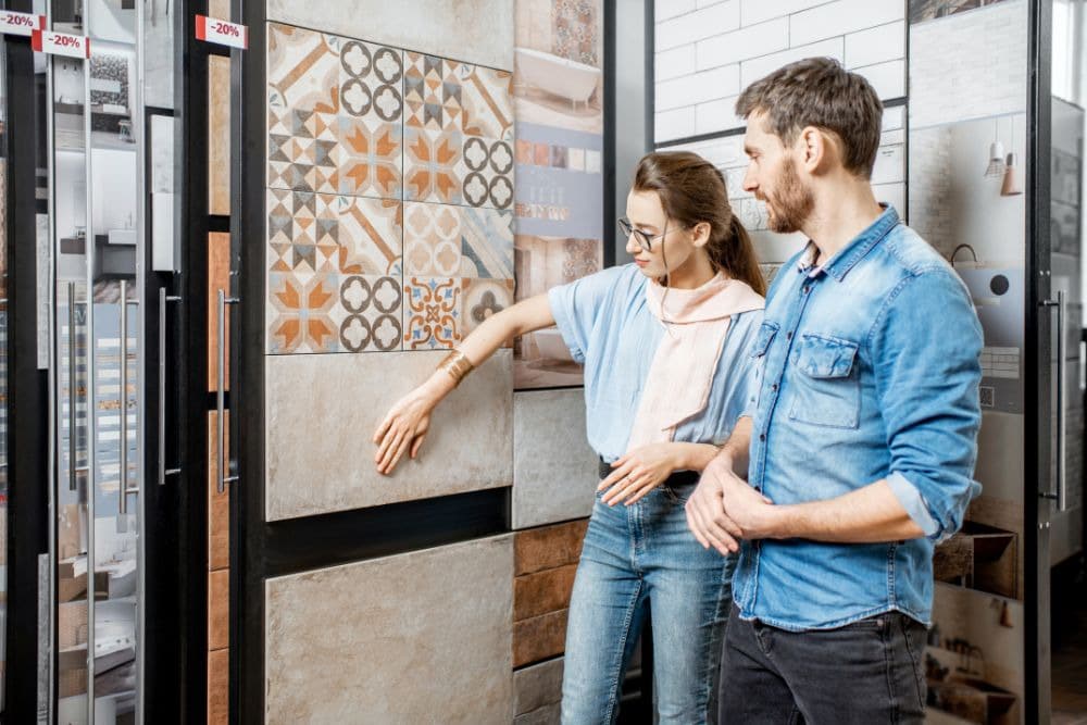 a couple inspecting tile samples in a shop