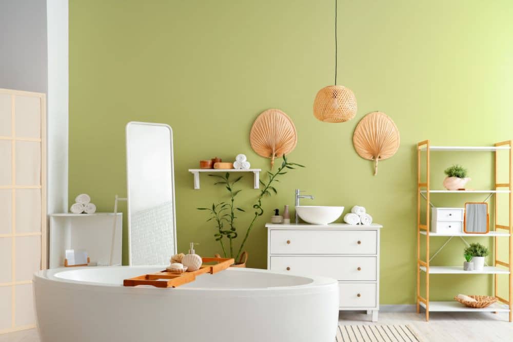 warm green bathroom with bathtub, vanity, large mirror, and shelves