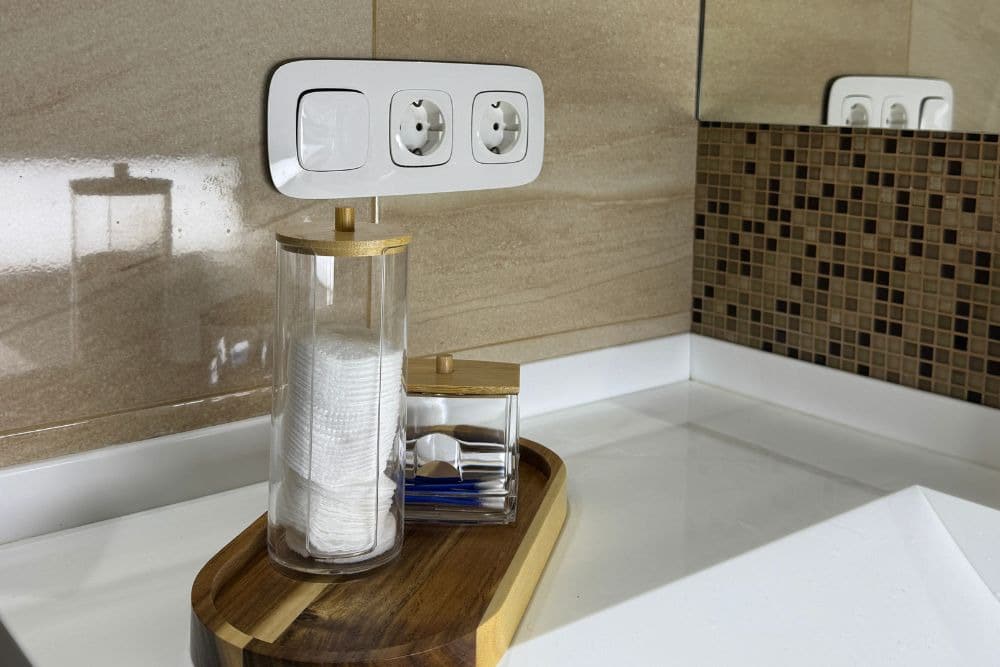 tray of toiletries in front of outlets that comply with seattle bathroom electrical code requirements