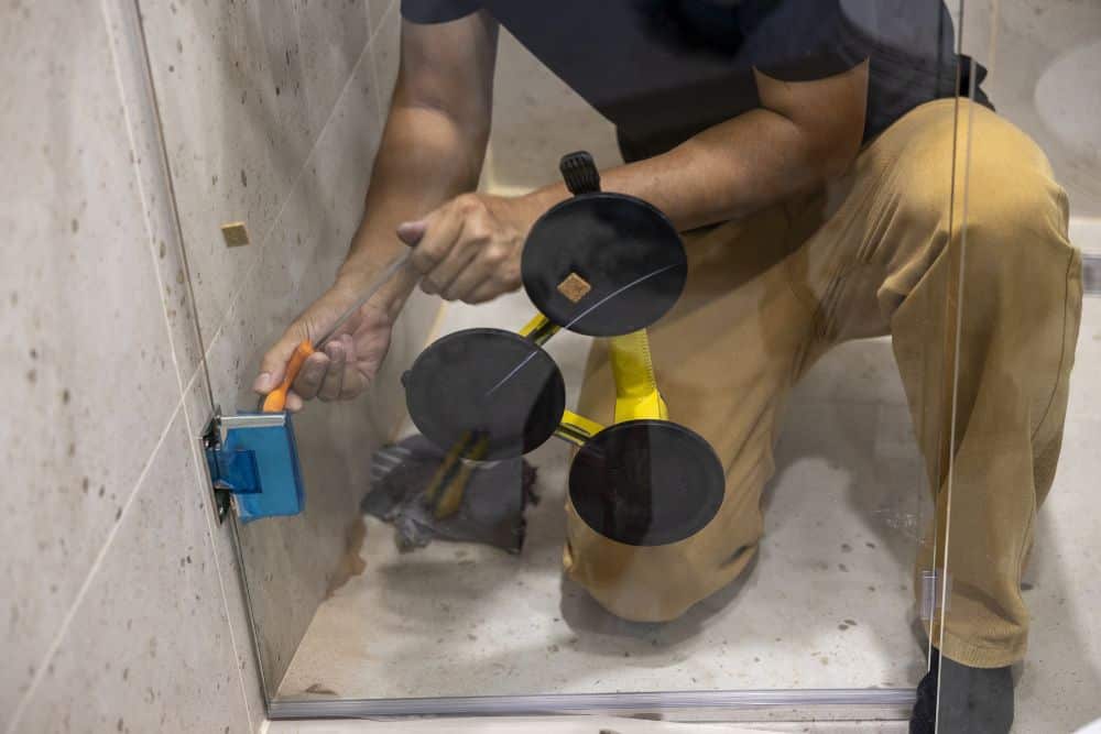 a seattle bathroom remodel contractor installing a shower glass partition.