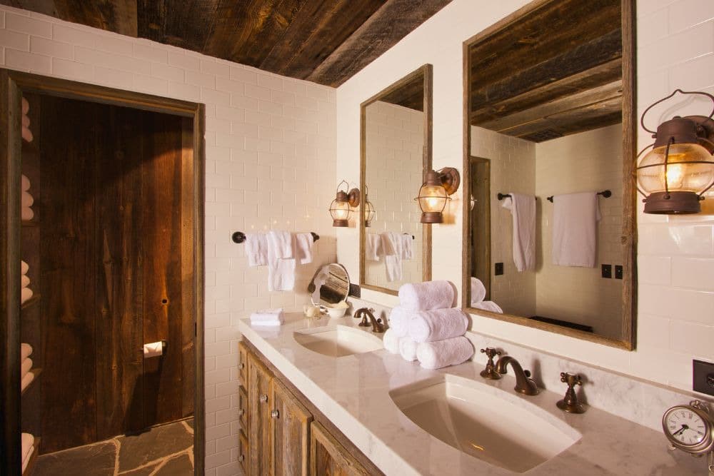 a classic seattle home interior showcasing why hollywood bathrooms could work in seattle homes, featuring towels, a vintage wood vanity, two mirrors, and a separate room for the toilet and shower behind a closed door.