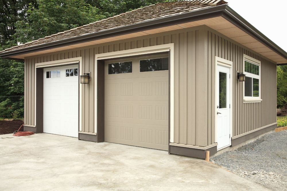 a modern brown seattle dadu featuring a flat concrete pavement in front of two large garage doors, representing an investment that carries a typical seattle dadu cost averaging $450,000 for a detached garage conversion.