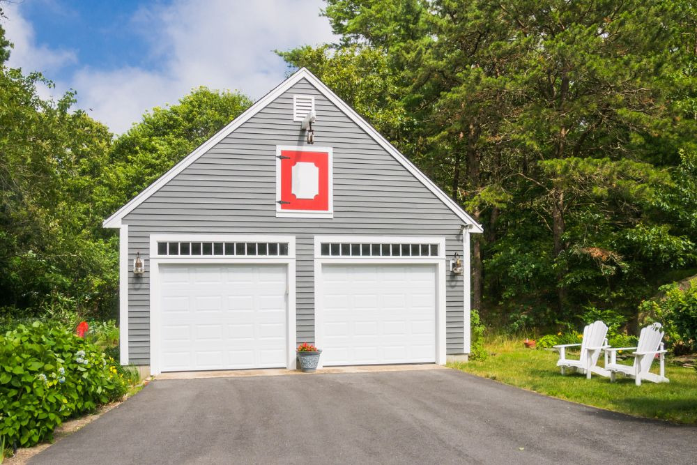 a modern, grey seattle dadu with two white garage doors, exemplifying how homeowners can achieve functional design and cut seattle dadu costs through smart choices without sacrificing construction quality.