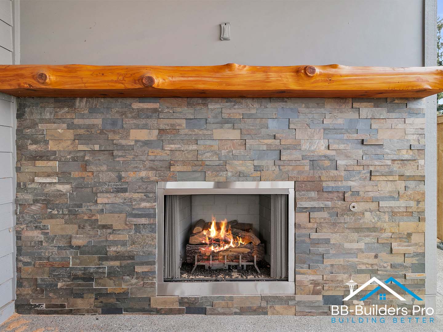 outdoor stone fireplace on a covered patio built by bb-builders pro near seattle