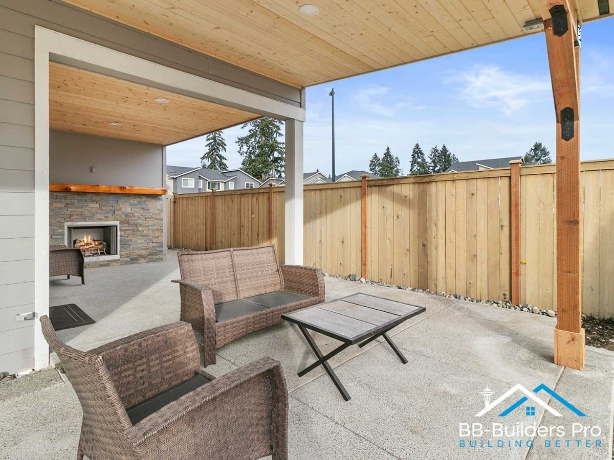 covered outdoor living space with a stone gas fireplace near seattle