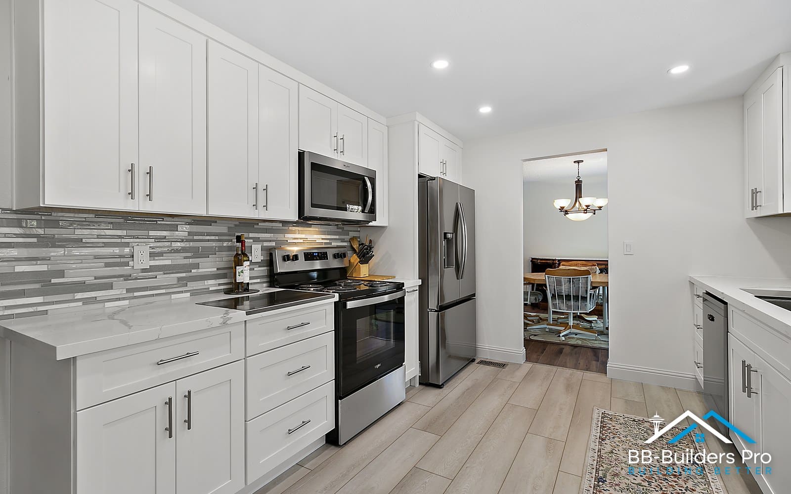 finished kitchen with range, microwave and glass tile backsplash after a kitchen remodel