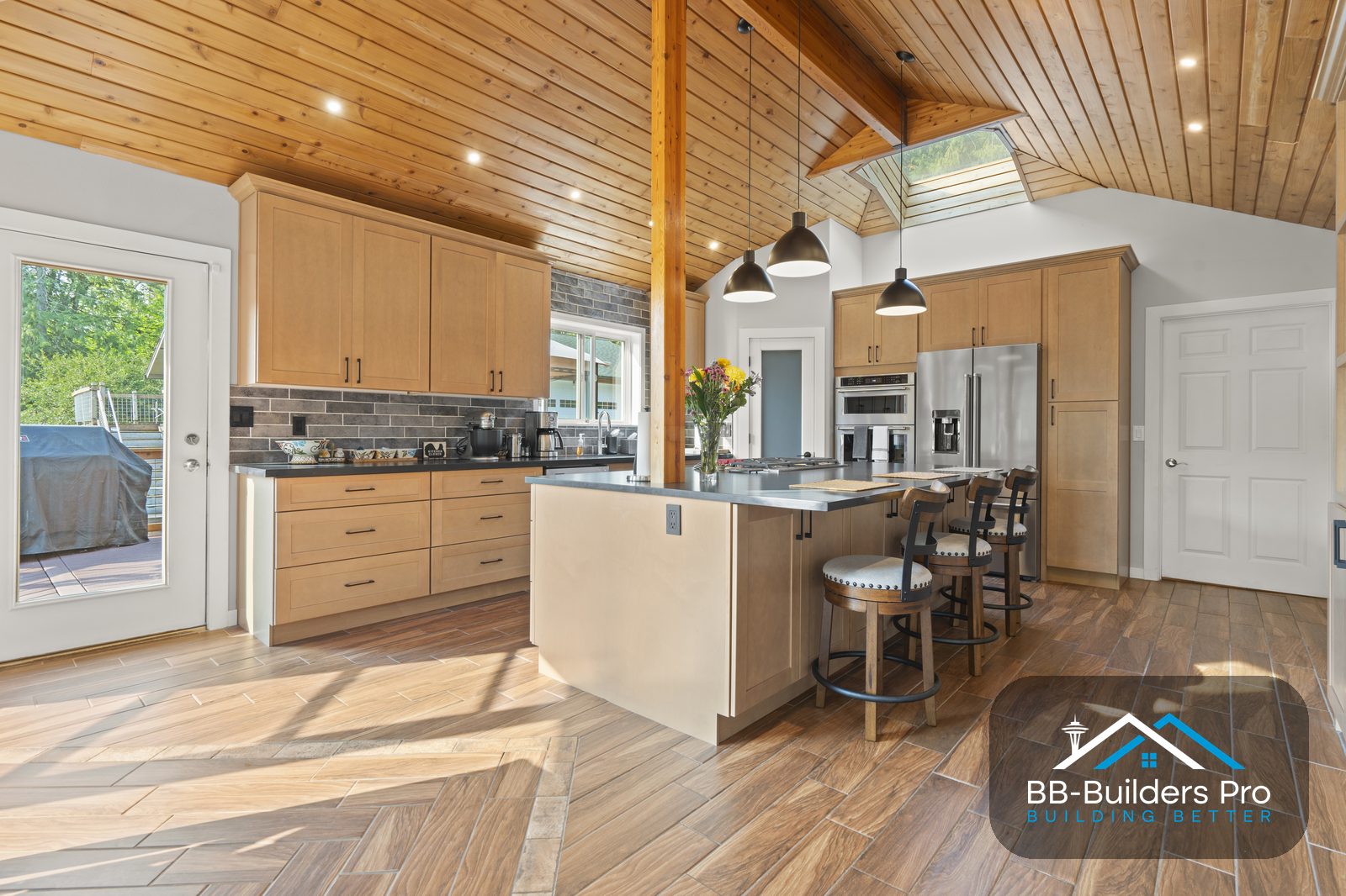 vaulted kitchen ceiling with sloped recessed housings and pendant lighting