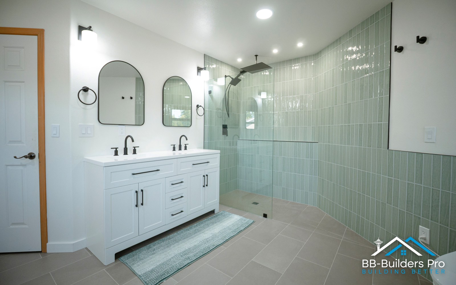 frameless glass shower enclosure beside a double vanity in a bathroom remodel